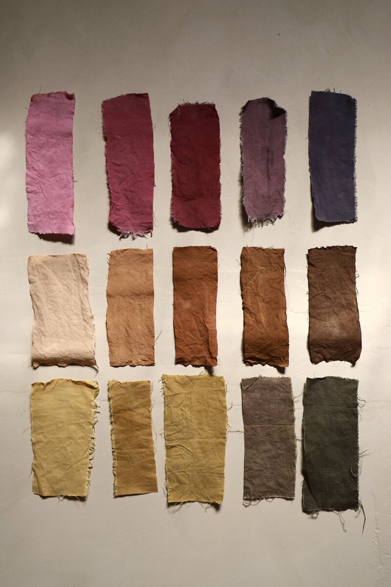 Colourful natural dye swatches on beige stone background