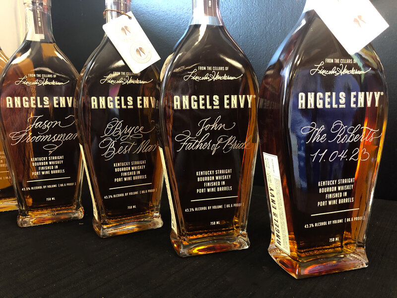 Row of engraved bottles of Angels Envy with calligraphy lettering