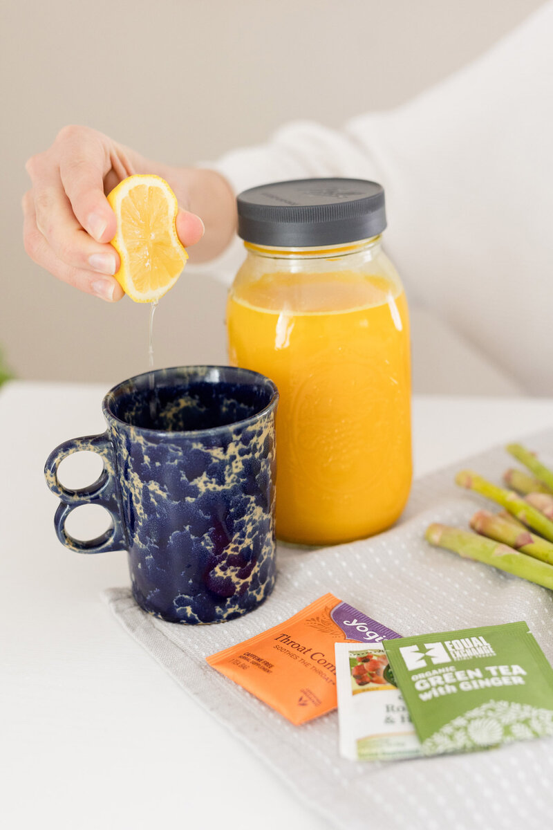 Grace squeezing lemon into a mug of tea