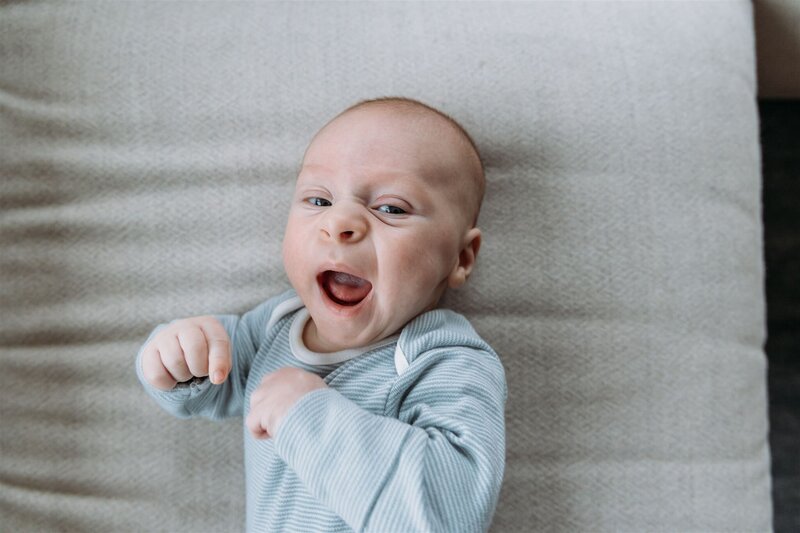 Family Photographer, a baby yawns on the bed