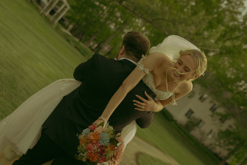 A woman holds her dress and lets it freely get caught in the wind while running through the forest