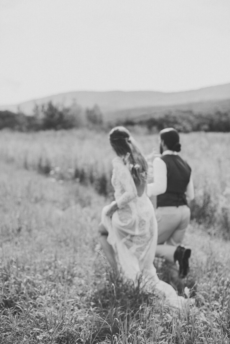 A bohemian bride and groom frolicking in a field