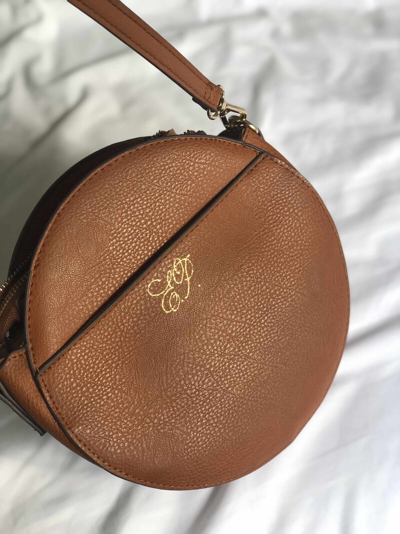 a purse with gold calligraphy E.P. initials