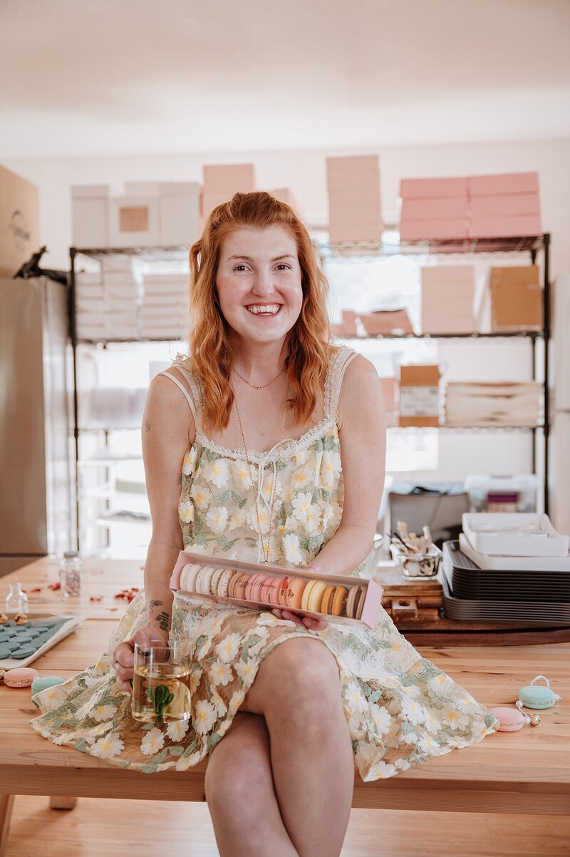 local Maple Ridge macaron baker holding her macarons in her shop during a Vancouver branding photoshoot