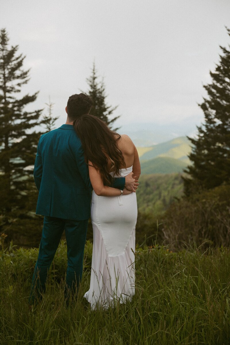 Couple standing and looking out to the mountain during an asheville elopement.