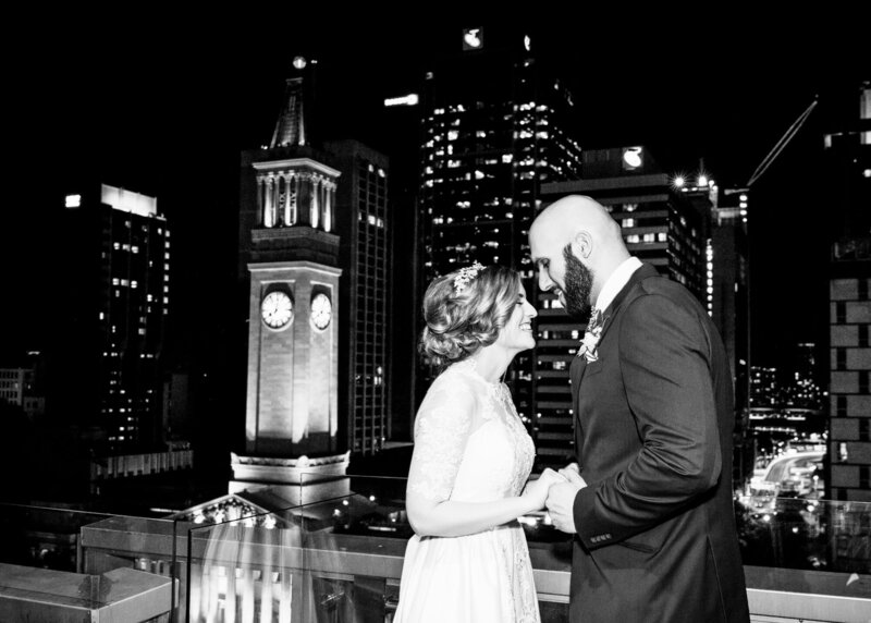 Wedding couple hold each other's hand with City lights at the back