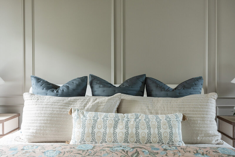 Cozy and elegant bedroom design in Roswell, Georgia with layered textiles, neutral tones, and custom furnishings by Megan Paterson Interiors.
