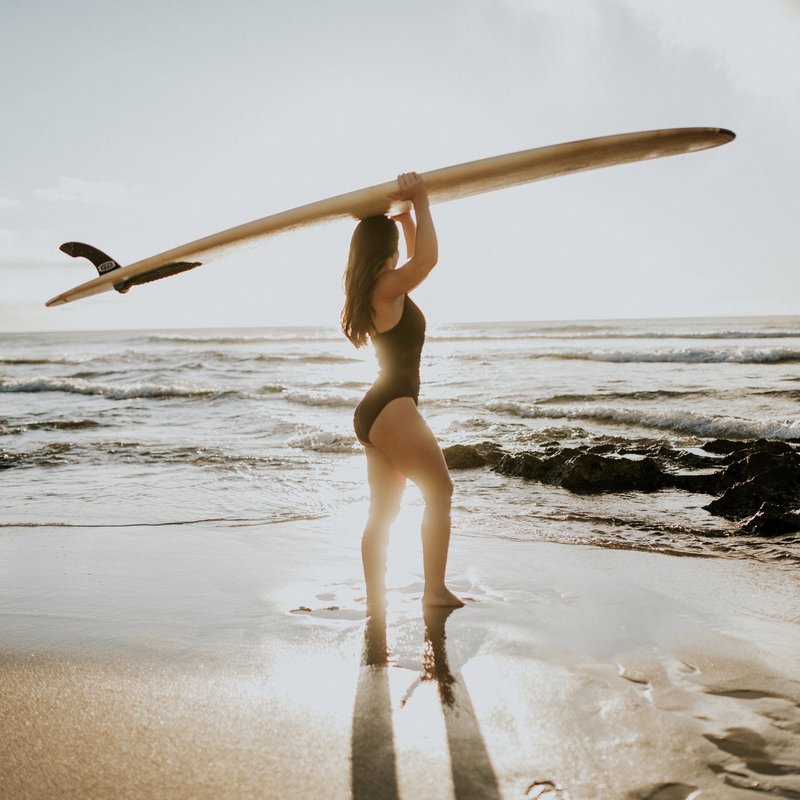 girl carrying surfboard
