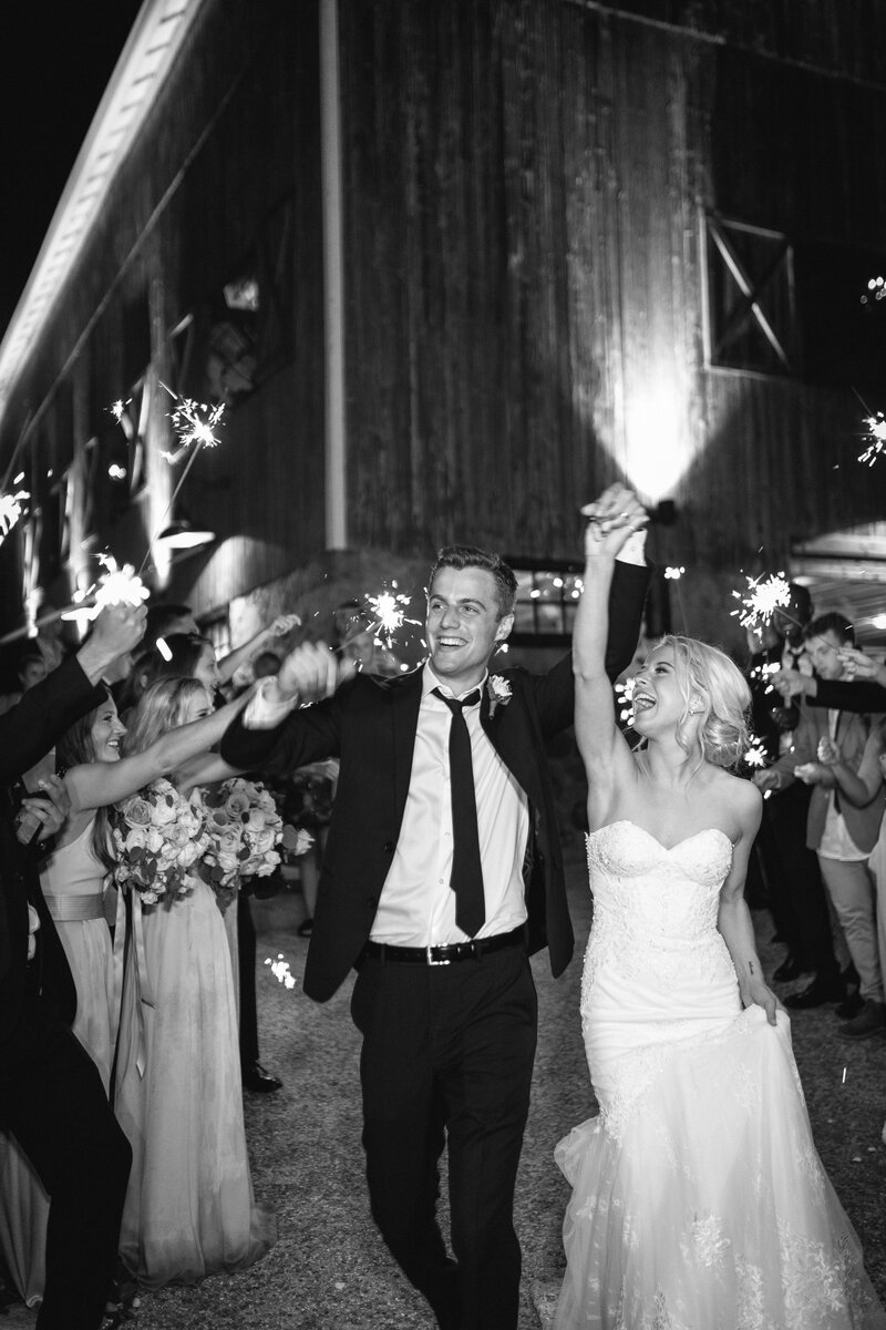 Bride and groom go through sparkler exit at farm wedding