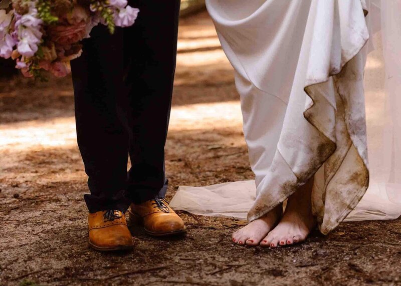 Bride standing barefoot in mud and groom wearing shoes