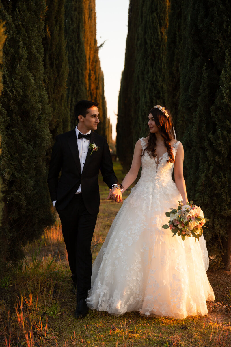 bride and groom walking hand in hand in cypress grove