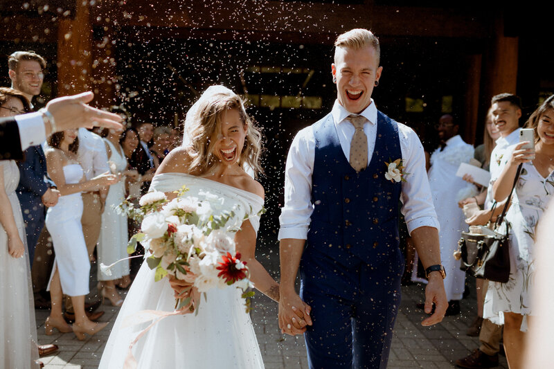 Married couple exiting their wedding ceremony in Whistler with big smiles
