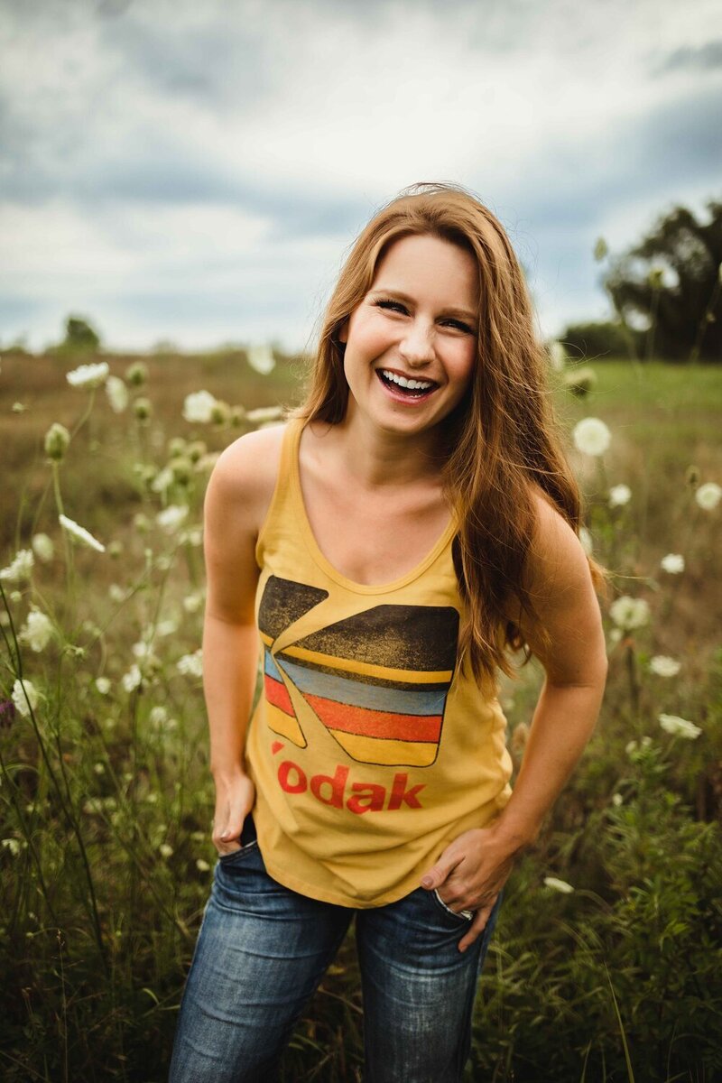 young woman wearing a Kodak tshirt standing in a field of wildflowers