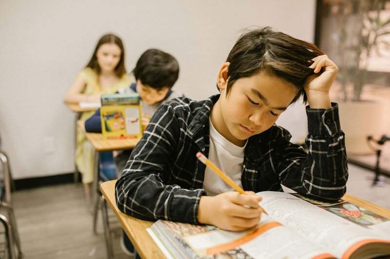 A middle school male student completing an assignment in his classroom