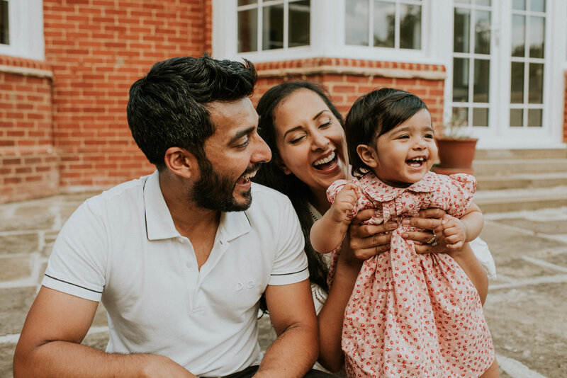 Couple holding toddler and laughing