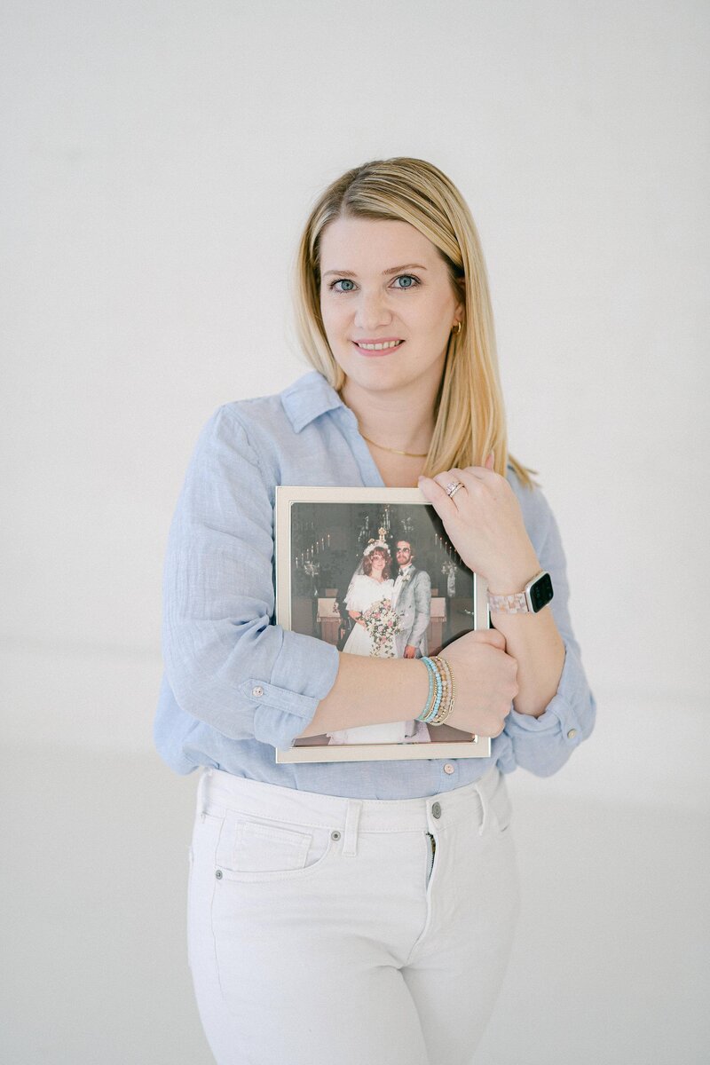 Wedding photographer holding a photo of her parents portrait on their wedding day