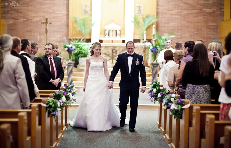 Bride and Groom walk down the aisle after their ceremony inside Saint John's in Longmont CO