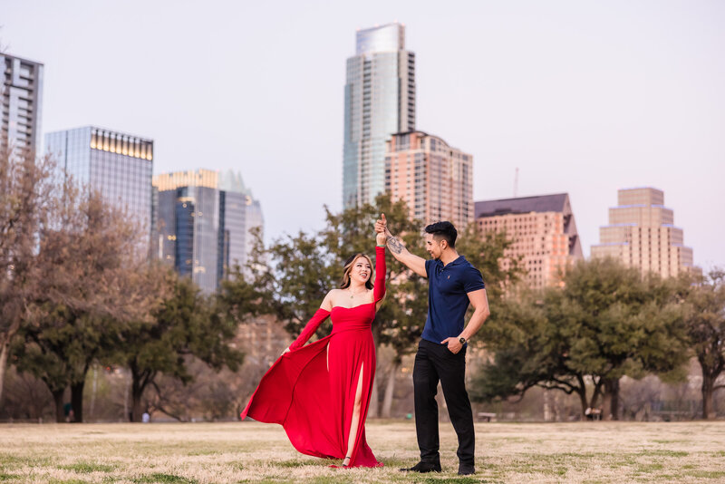 Couple dance in the middle of the park during their engagement session at Butler Park in Austin, Texas. Photo taken by Austin Engagement Photographers, Joanna & Brett Photography