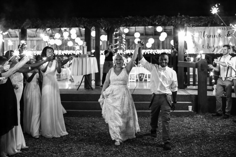 Guests wave sparklers as bride and groom exit Betsy's Barn wedding