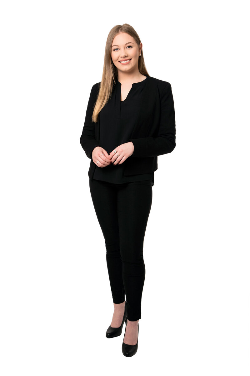 Business woman leaning against white wall