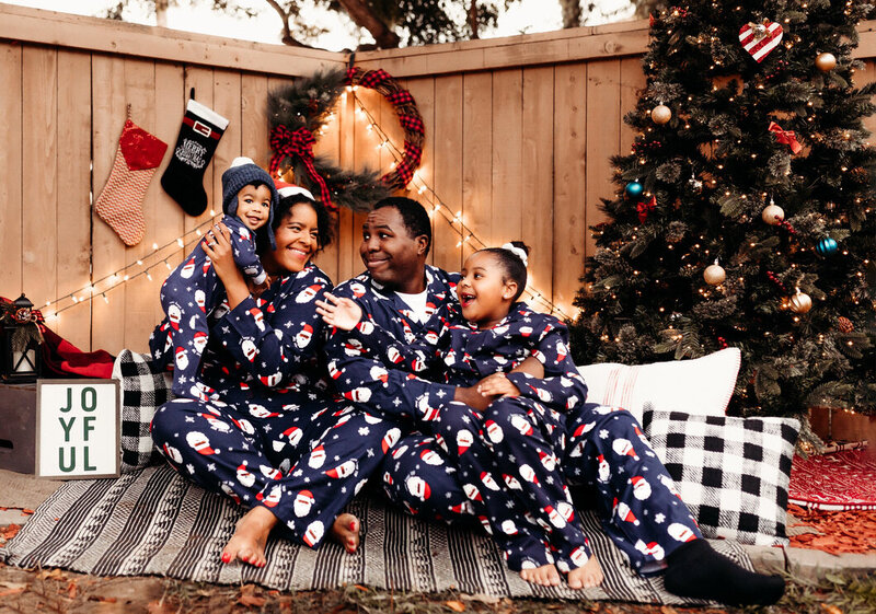 Family of 4 posing in matching christmas pajamas
