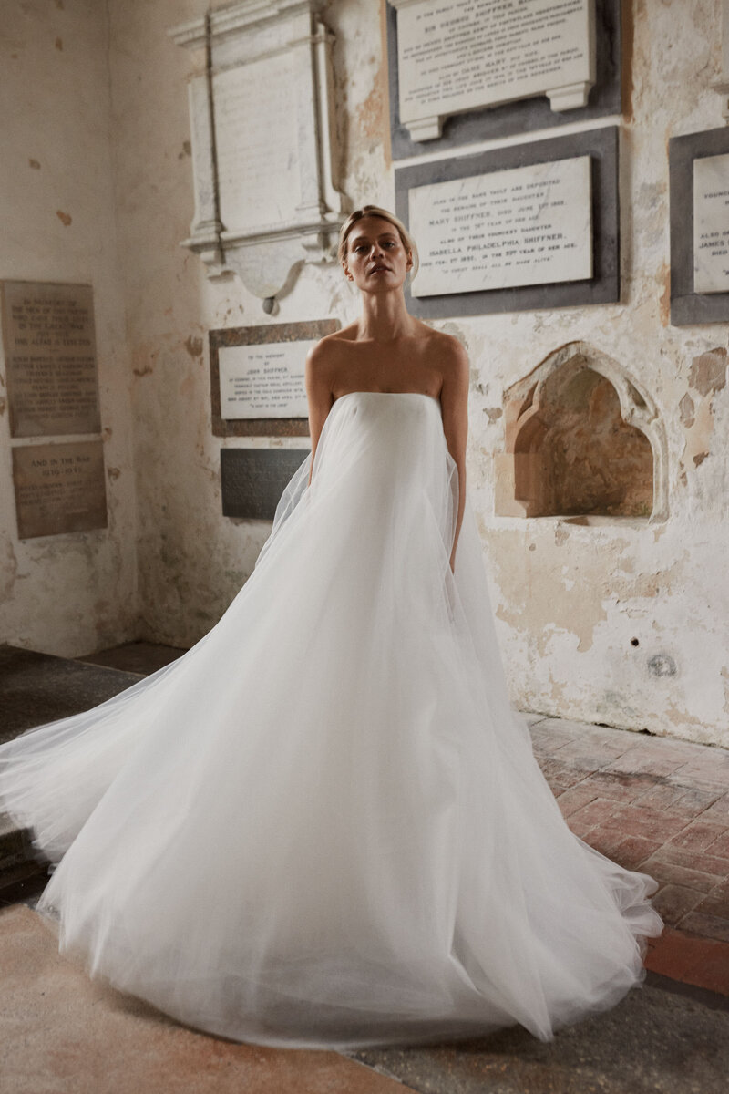 Bride in church wearing flowing layered wedding corset wedding dress