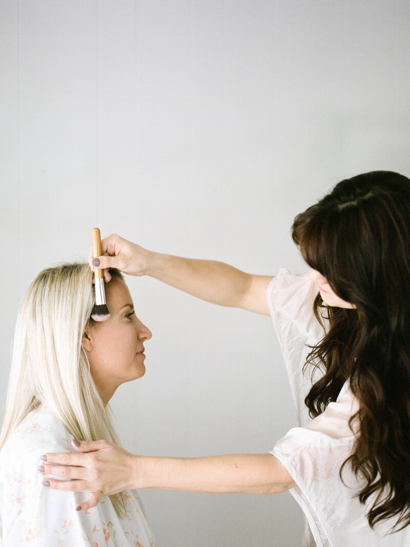 hair and make-up artist applying blush
