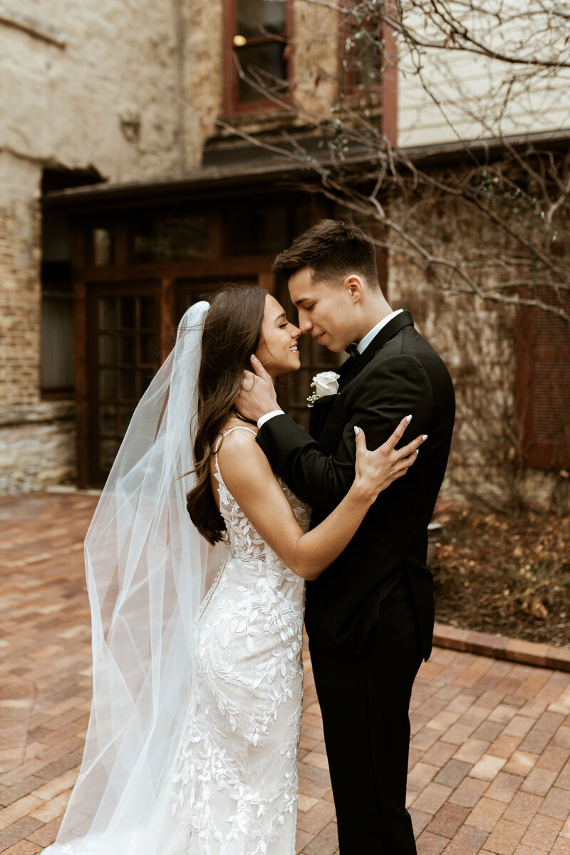 Bride and groom embracing nose to nose in front of Riverside Receptions venue