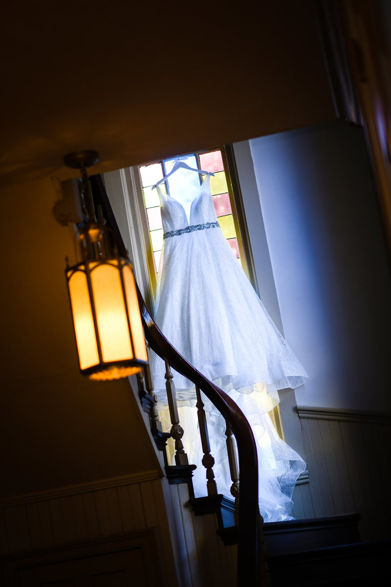 Beautiful Wedding Photography: Bridal gown hands on staircase with stained glass, First Baptist Church of Starkville