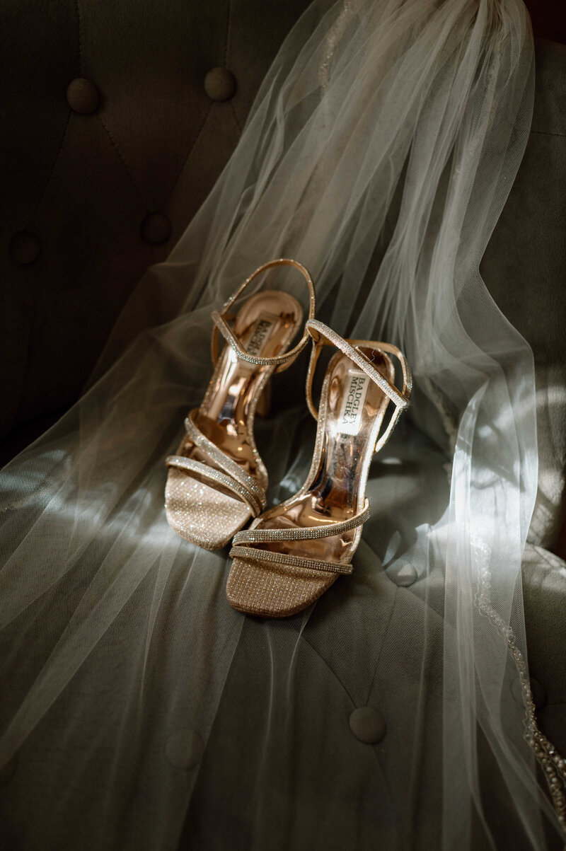 Golden bridal sandals elegantly placed on the veil, adding a touch of sophistication to the ensemble