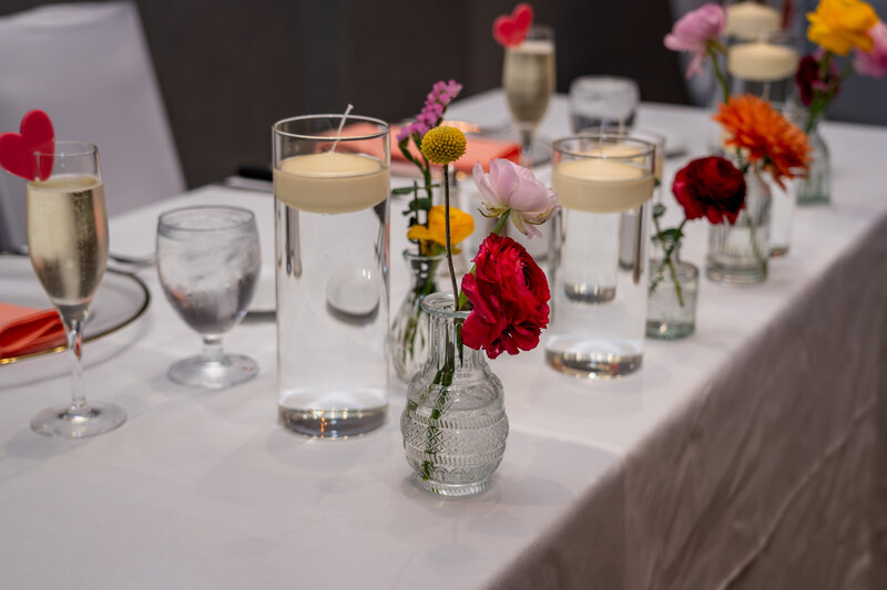 Close-up of wedding reception table with blush napkins, flowers, and glasses – photographed by wedding photographer Niko Coric – Lumen Clarity Media