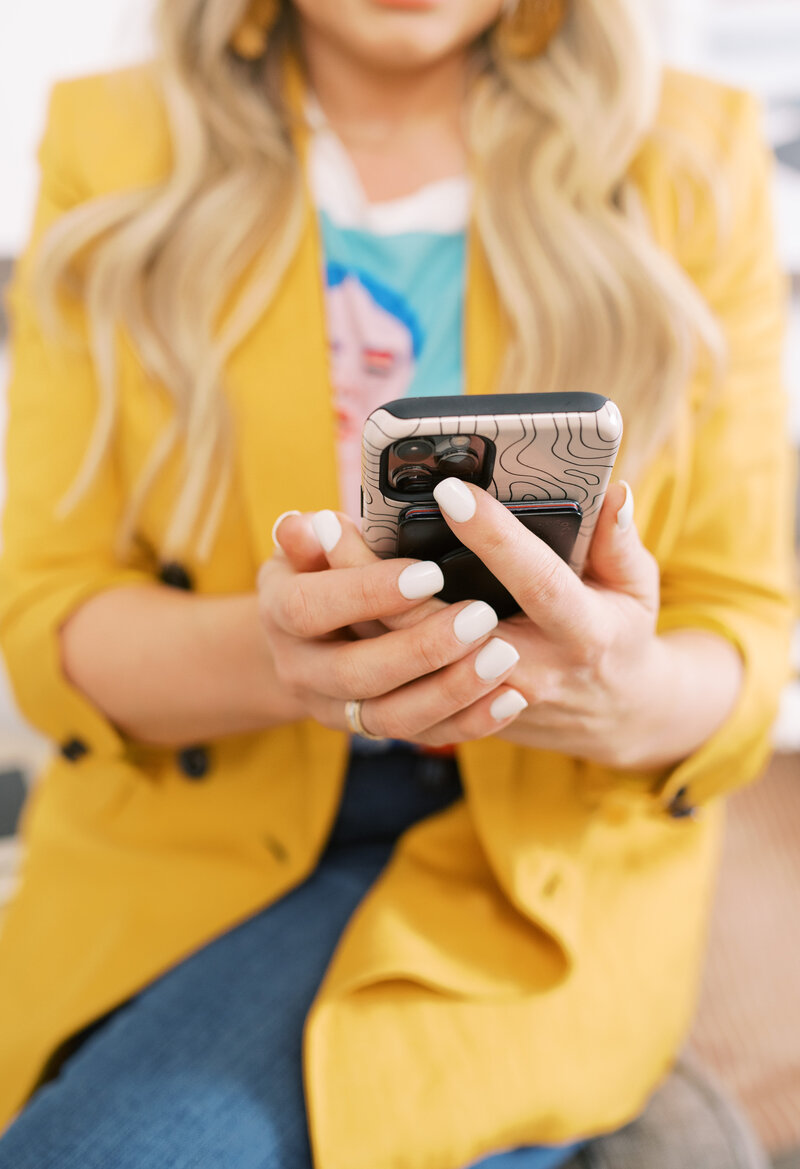 Holding phone, social media marketing using Instagram for small businesses.