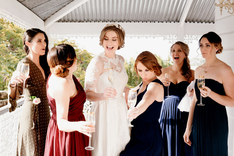 Bride having champagne with the Bridesmaids and  laughing