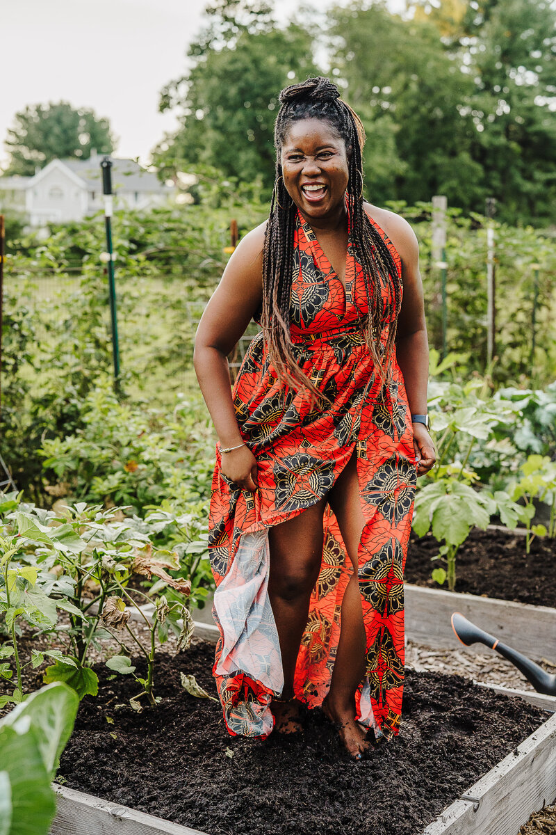 woman in African dress dances barefoot in garden