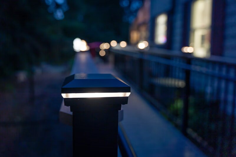 Post cap lights on deck railing at nighttime. 