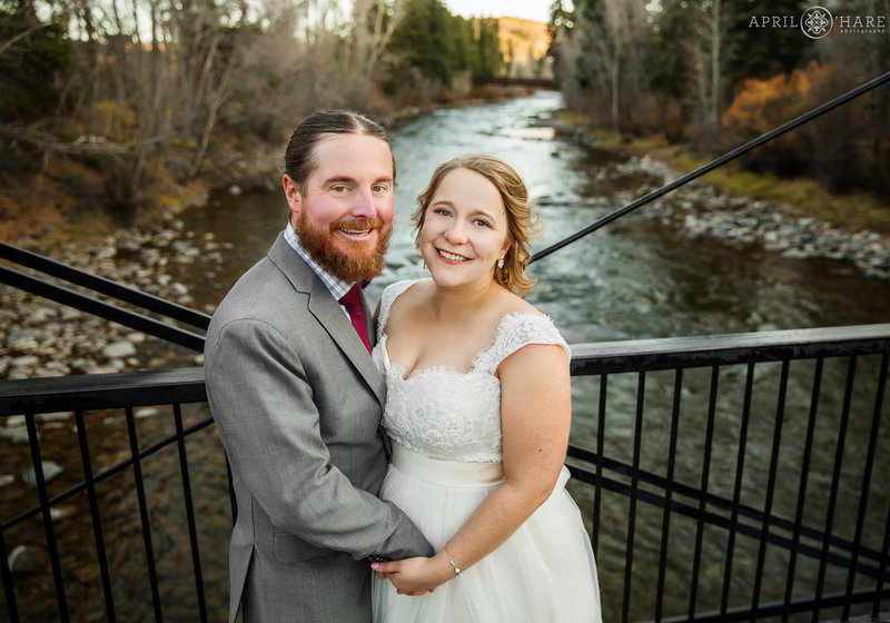 Cute photo of a couple on their wedding day on the historic bridge over the Blue River at the SIlverthorne Pavilion