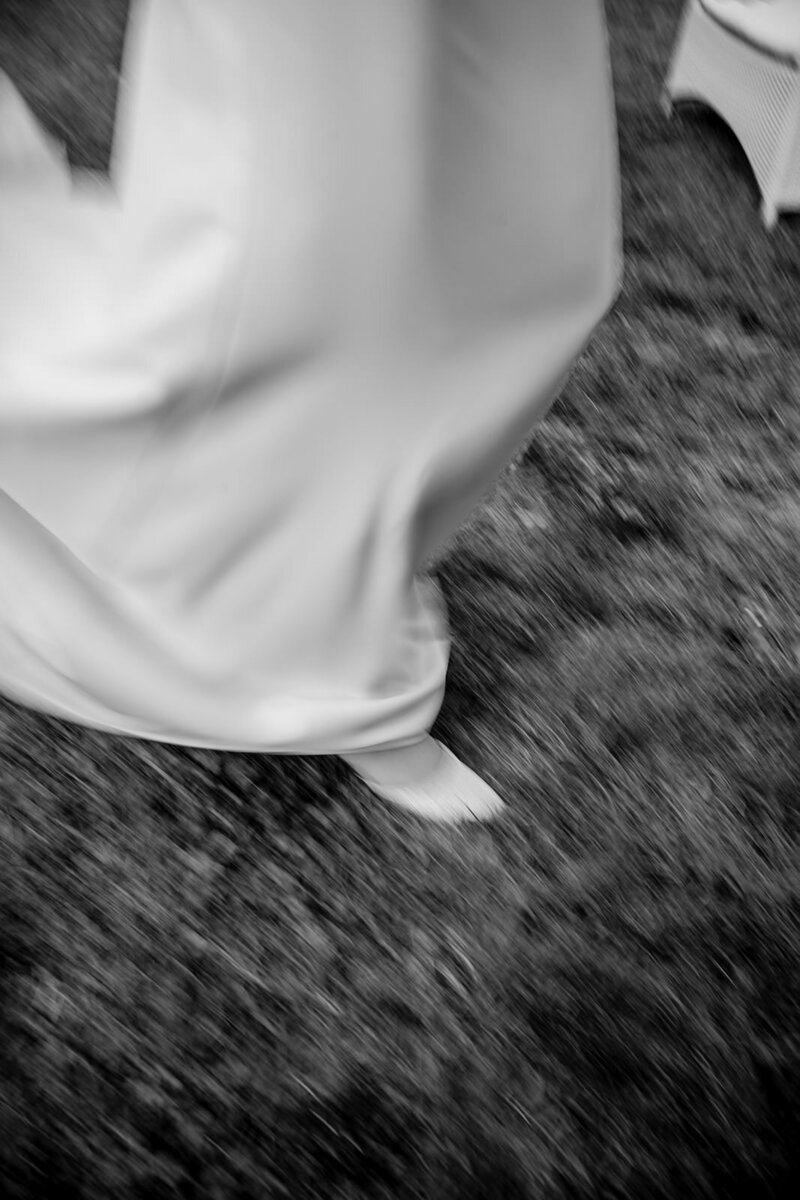 Blurred picture of bride shoe wlaking on a grass