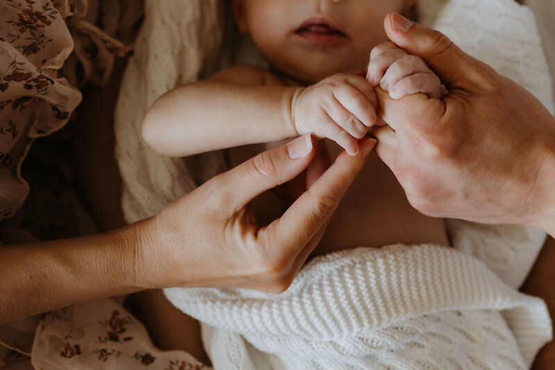 newborn holding parents' hands