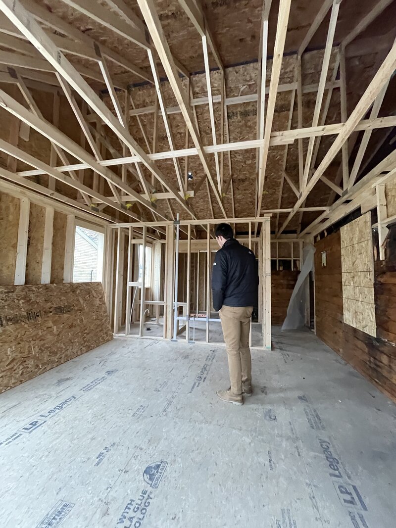 man stands in house under construction