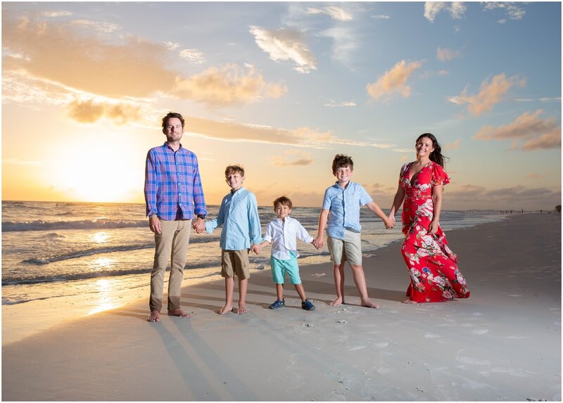 A wide angle shot of a family of five on Coquina Beach at sunset