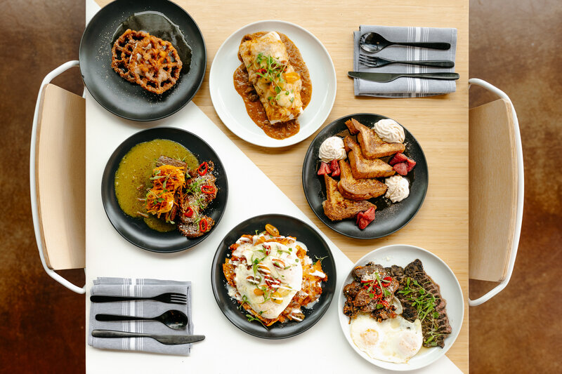 A photo of a variety of brunch dishes sits at a table.