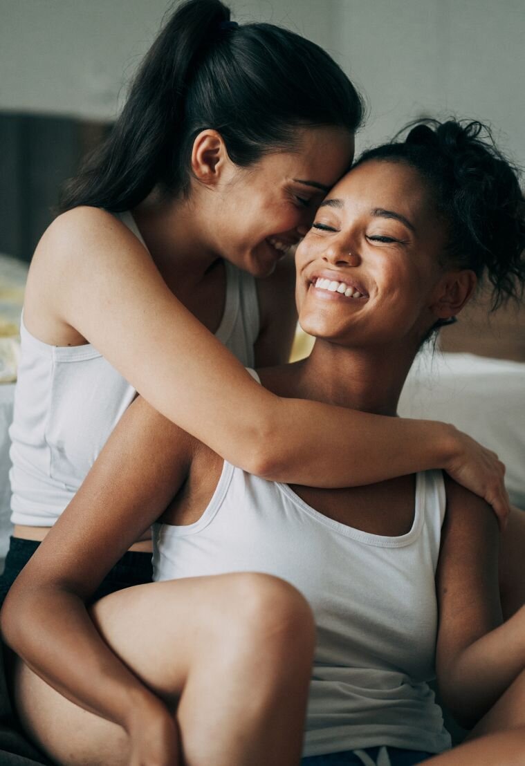 lesbian couple hugging and laughing after transforming their relationship with couples therapy
