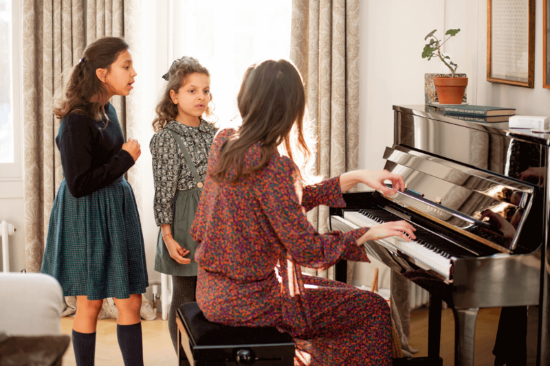Marta at piano with two students singing