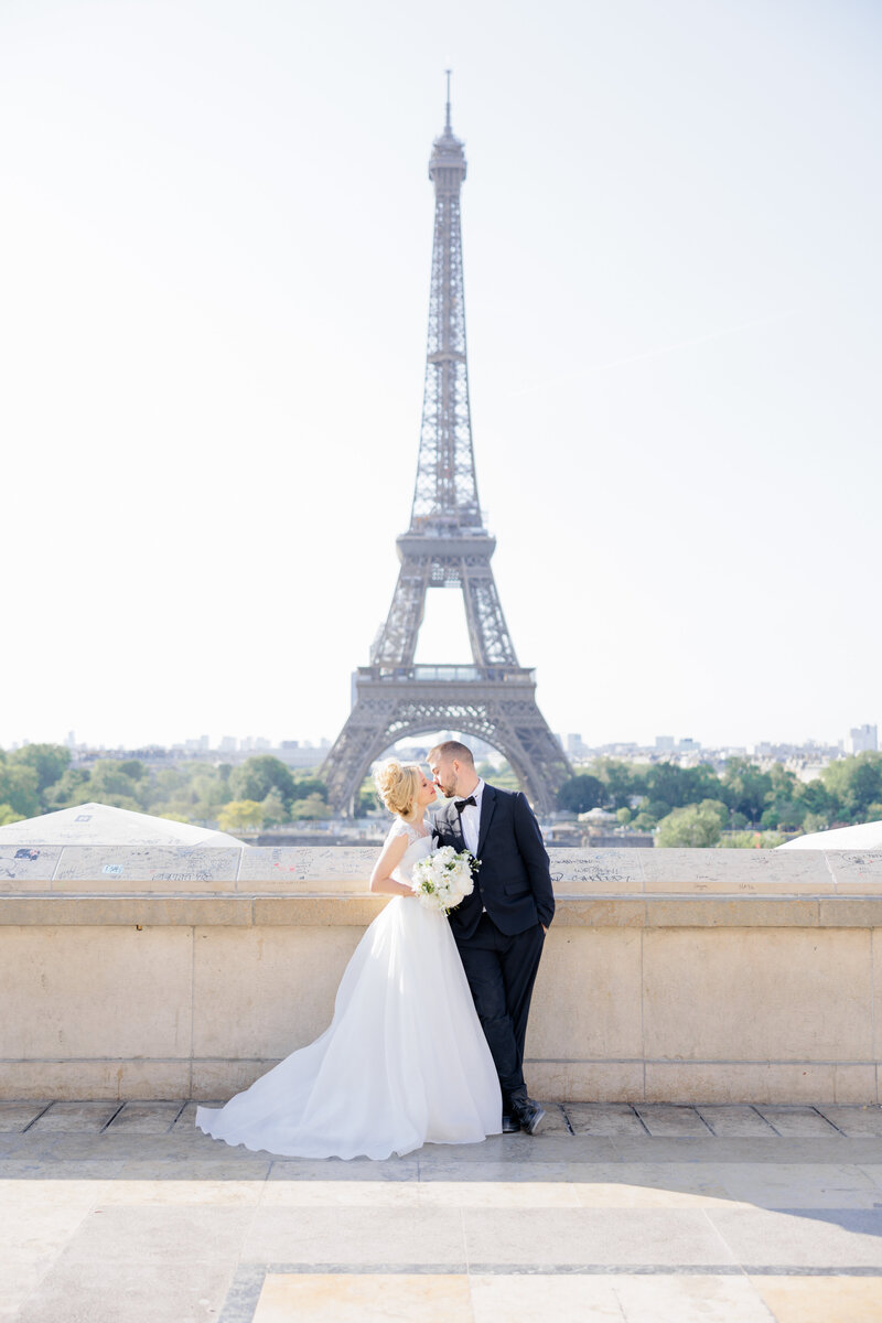 A spring sunrise wedding photography session on the steps in front of the Eiffel Tower in central Paris.