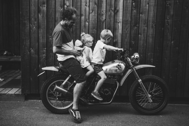 Dad and kids sitting on a motorcycle together