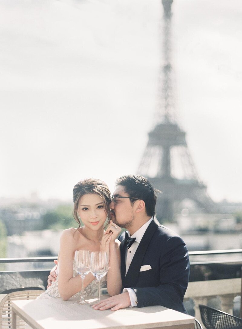 Couple sitting at table in front of Eiffel Tower