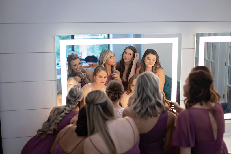 bridesmaids and bride at mirror