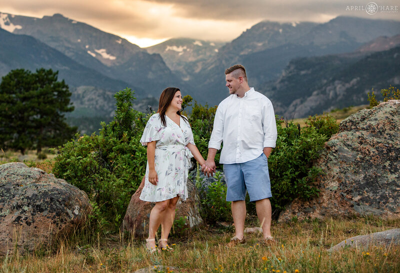 Cute couple holds hands at Moraine Park at Rocky Mountain National Park in Estes Park