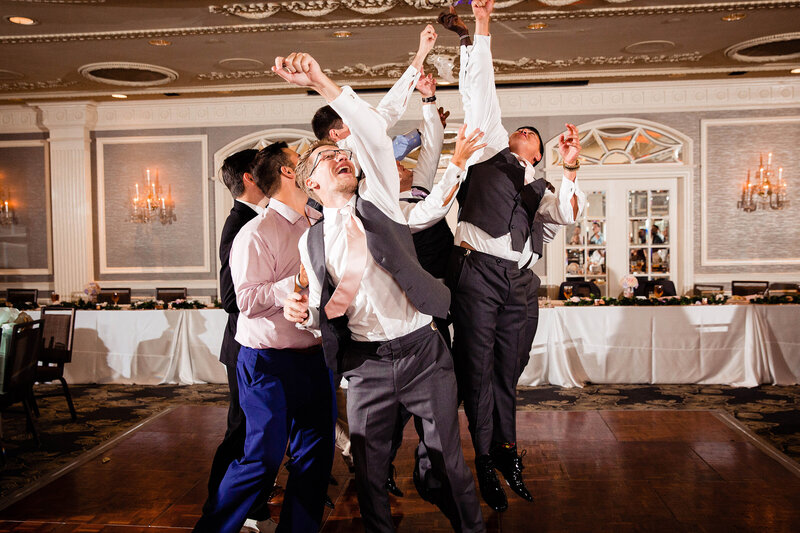 Guys jumping in the air to catch the garter