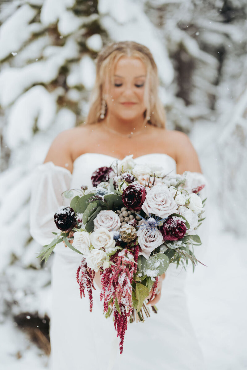 bride with winter bouquet in the snow